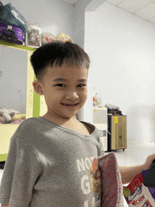a young boy wearing a gray shirt that says not g on it