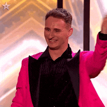 a man wearing a bright pink jacket and black shirt