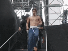 a man without a shirt is walking down stairs with a man carrying him
