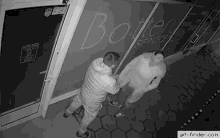 a couple of men are standing in front of a building .