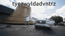a man stands in front of a large bell next to a car that says tyezwyldadvntrz online