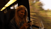 on phone brynn elliott in the train tongue out smile