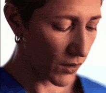 a close up of a woman 's face with a blue shirt
