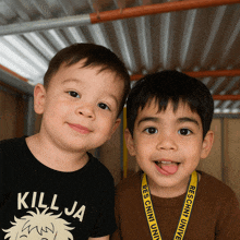 two young boys are posing for a picture and one of them is wearing a killja shirt