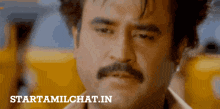 a man with a mustache is looking at the camera with the words starttamilchat.in below him