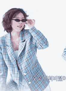 a woman wearing sunglasses and a plaid jacket with chinese writing on the bottom