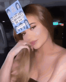 a woman wearing a card that says which kardashian are you