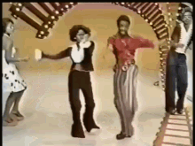 a group of people are dancing in front of a colorful archway