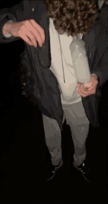 a man with curly hair is holding a bottle of alcohol