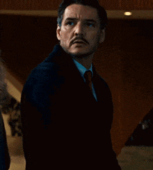 a man with a mustache wearing a suit and tie is standing in front of a woman .
