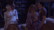 a group of people standing in a living room and one of them says i ate half a chicken
