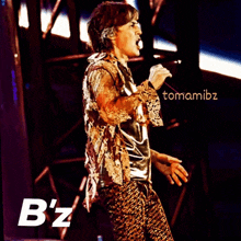 a man with a tattoo on his arm sings into a microphone on stage