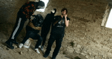 a group of people standing in front of a brick wall with one wearing a sweatshirt that says " cruel "