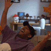 a man in a purple shirt is laughing with his arms outstretched