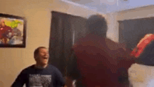 a group of people are dancing in a living room while a man is laughing .