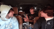 a group of young men are sitting in a car and one of them is wearing a shirt that says ' miami '
