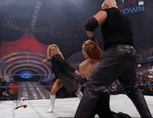 a wrestler kicking another wrestler in a ring with a sign that says ' own ' on it