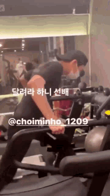 a man is using a machine in a gym with the number 1209 on the bottom right