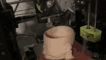 a 3d printer is printing a baby 's head on a red surface