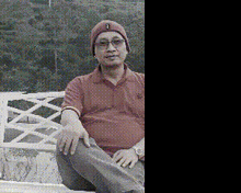a man wearing a hat with the letter b on it is sitting on a bench