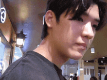 a close up of a man 's face in front of a sign that has the letter g on it