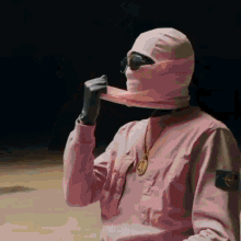 a man wearing a pink sweatshirt and a pink mask on his face