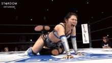 a woman in a wrestling ring with a banner that says stardom