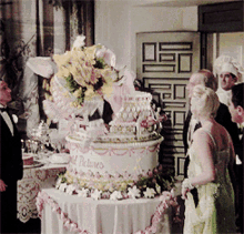 a woman in a green dress stands in front of a wedding cake that says ' princess ' on it