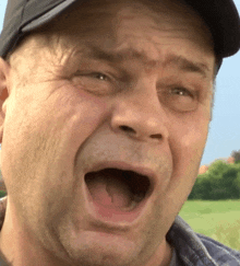 a close up of a man making a funny face with his mouth open