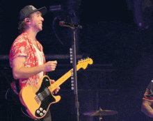 a man singing into a microphone and holding a guitar