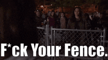 a woman stands in front of a chain link fence with the words f * ck your fence