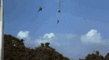 a man is hanging from a rope in the air with a helicopter behind him