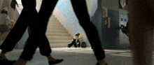 a girl sits on the floor in front of a staircase that has the letter g on it