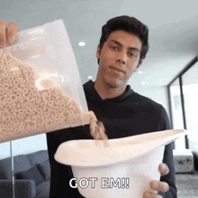a man pouring cereal into a white bowl with the words got em written on it