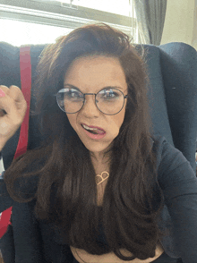 a woman wearing glasses and a necklace with the letter d on it