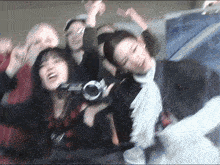 a blurry photo of a group of people with one woman holding a camera that says ' nikon ' on it