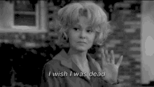 a woman is waving her hand in a black and white photo and says `` i wish i was dead '' .