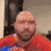 a bald man with a beard is eating a bag of doritos .