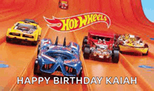 a bunch of hot wheels cars are racing down a track .