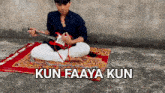 a man is playing a guitar while sitting on a rug with kun faaya kun written below him