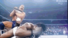 a couple of men are wrestling in a ring .