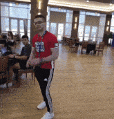 a man wearing a red shirt that says never back down on it