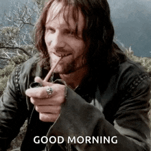 a man with a beard is smoking a pipe and saying good morning .