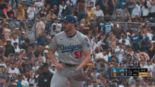 a dodgers pitcher stands in front of the crowd