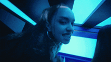a woman in a dark room with blue lights on her face
