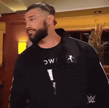 a man with a beard is wearing a black shirt that says i mc