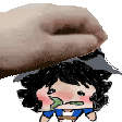 a hand is holding a cartoon character 's head with a green leaf in its mouth .