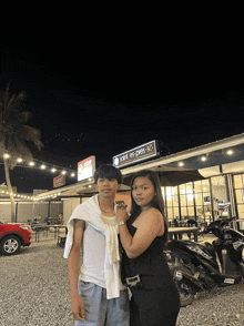 a man and a woman pose for a photo in front of a restaurant called saint 's press
