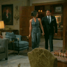 a man in a suit and tie stands next to a woman in a dress