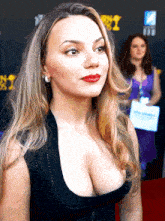 a woman stands on a red carpet in front of a sign that says ' netflix ' on it